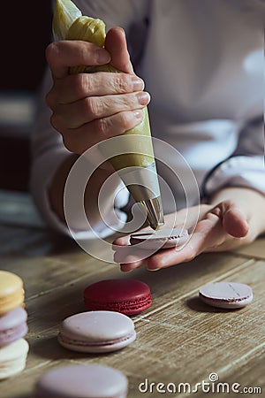 Close up of female pastry chef's hand cooking delicious macaroon Stock Photo