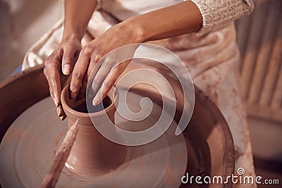 Close Up Of Female Potter Shaping Clay For Pot On Pottery Wheel In Ceramics Studio Stock Photo