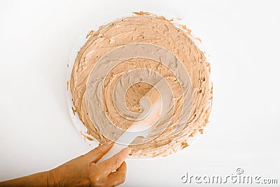 Close-up of female wrinkled hand ofcook decorating cake with cream filling using spatula Stock Photo