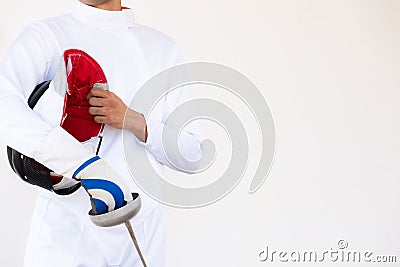 Close-up of a fencer in white fencing suit and holding his mask Stock Photo