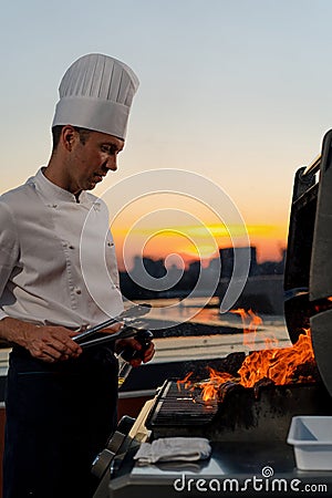 Close-up of filet mignon vegetables and meat on a bbq grill on a skyscraper rooftop at sunset. Fire in the barbecue Stock Photo