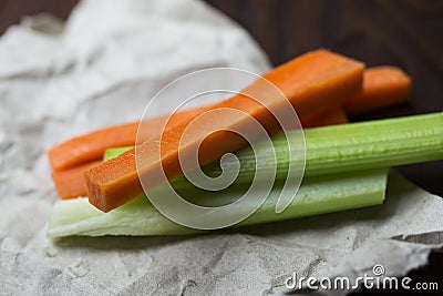 Close up filled frame shot of party snack food. A bunch of crunchy orange carrot and juicy green celery sticks laying on a piece Stock Photo