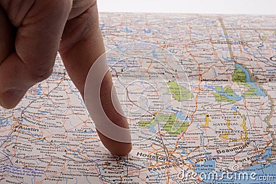 Close up of finger pointing to Houston, Texas on colorful map with selective focus, shallow depth of field, background Stock Photo