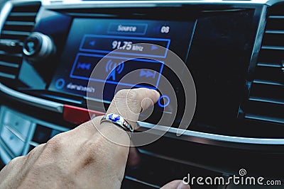 Close-up finger press turn the music, on touch screen digital in car Stock Photo