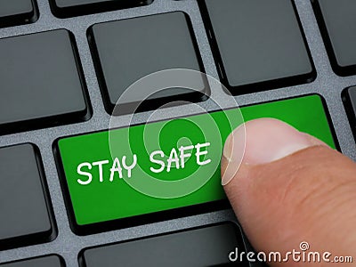 Close up finger pressing stay safe key on computer keyboard prevention message concept Stock Photo