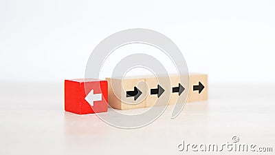 Close-up finger pushing arrow icon on cube wooden toy block stacked pointing to opposite direction Stock Photo