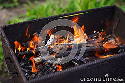 Close up of fire on chargrill. Dry sticks smoulder. Concept of cooking on grill Stock Photo