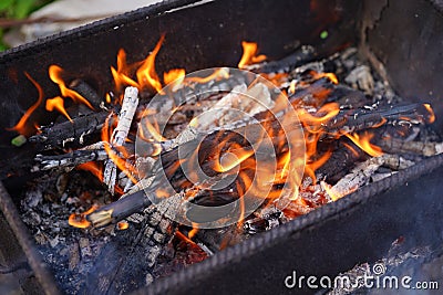 Close up of fire on chargrill. Dry sticks smoulder. Concept of cooking on grill Stock Photo