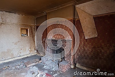 Close up of fireplace in derelict 1930s deco house, with wallpaper peeling off the wall. Rayners Lane, Harrow UK Editorial Stock Photo