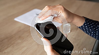 Young woman leaning electronic device screen with antiseptic napkin. Stock Photo