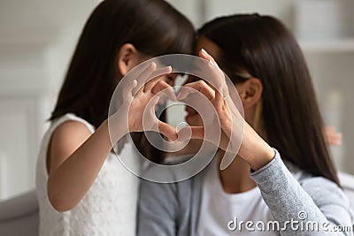 Mothers and daughters fingers showing heart symbol of love Stock Photo