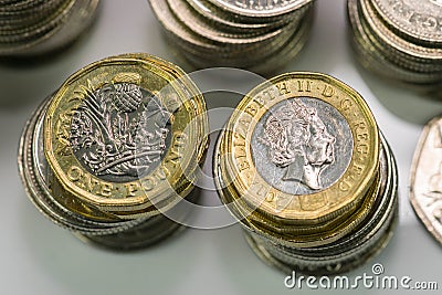 Close up focus photos of new United kingdom Pound coin, among other British coins Editorial Stock Photo