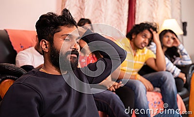 Close up of focus on young disappointed man, Group of young sports fans sad over loss of game while watching live streaming sports Stock Photo