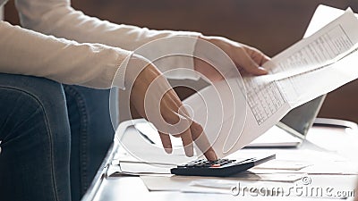 Focused young woman managing household finances indoors. Stock Photo