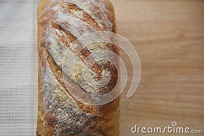 Close up food image of a fresh home made artisan white bread loaf on a cream cloth and wood board background Stock Photo