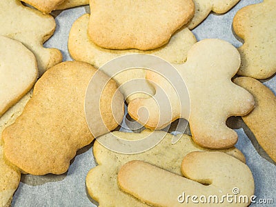A close up food photograph of a pile of baked sugar Christmas cookies in various shapes including gingerbread man, candy canes and Stock Photo