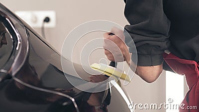 Close-up footage of young male worker taking care of black new car, polishing it to achieve glancy shine. stock footage Close-up footage of young male worker taking care of black new car, polishing it to achieve glancy shine. stock footage