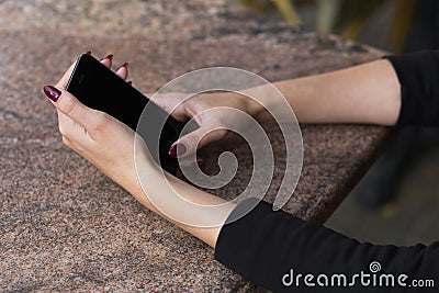 Fragment image of a stylish girl who holds a phone in her hands Stock Photo