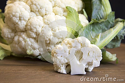 Raw cauliflower head and floret on wooden board Stock Photo