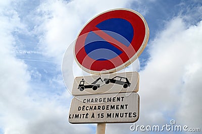 Sign indicating in fernch a loading and unloading area limited to fifteen minutes under penalty of impoundment Stock Photo