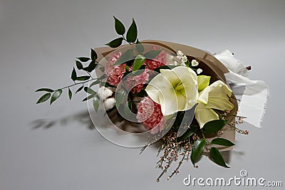 Close-up fresh bouquet of hippeastrum, allium, carnation, ruscus, genista, cotton on a gray background, selective focus Stock Photo