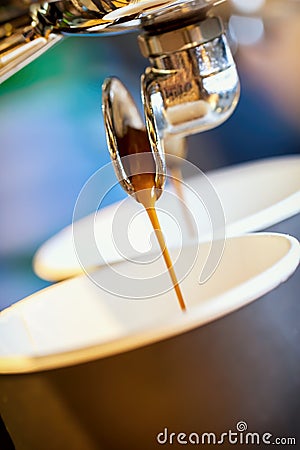 Close-up fresh espresso pours in disposable cup, Italian espresso machine. Coffee culture, professional coffee making Stock Photo