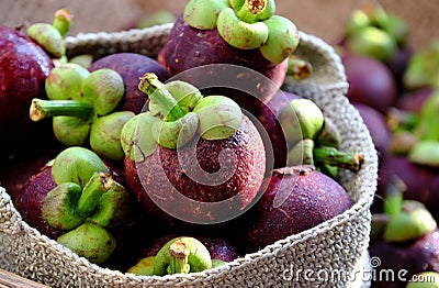 Close up fresh Mangosteens fruit in handbag on burlap background Stock Photo