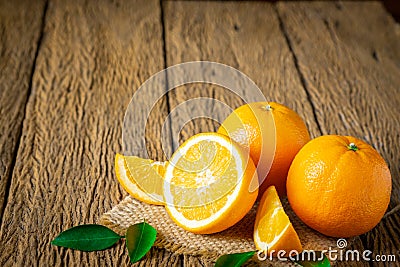 Close-up of Fresh oranges, half-cut fruit, slice with green leaves on an old wood vintage table. Stock Photo