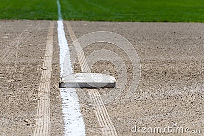 Close up of freshly chalked baseline, with base plate, dirt and grass, empty baseball field on a sunny day Stock Photo