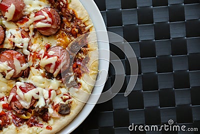 Close up of freshly home made pizza on a white plate with cheese, meat, onions, spicy products. Italian traditional food Stock Photo