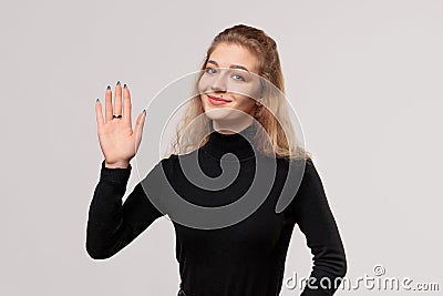 Close up blonde girl is saluting with hand with happy expression, showing five fingers, friendly welcome gesture Stock Photo