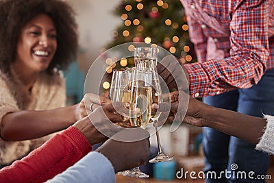 Close Up Of Friends Making A Toast With Champagne As They Celebrate Christmas At Home Together Stock Photo