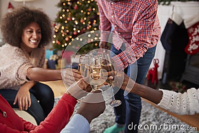 Close Up Of Friends Making A Toast With Champagne As They Celebrate Christmas At Home Together Stock Photo