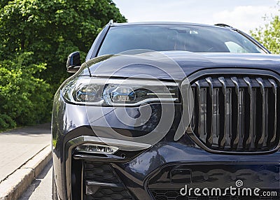 Close-up in front of a new black prestige car, expensive status car SUV, headlights, radiator grille, bumper, hood Stock Photo