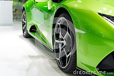 Close up front of new green car with Magnesium alloy wheel parking on car showroom. Dealership office or retail shop and Stock Photo