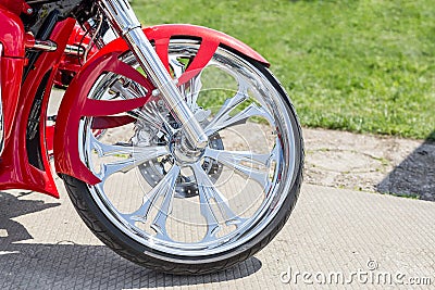 Close-up front part of retro custom motorcycle. Shining chrome vintage bike wheel with red fender Stock Photo