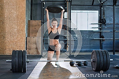 Close up front portriat of a woman is lifting weight while working out in gym. Exercise for legs. Healthy lifestyle Stock Photo