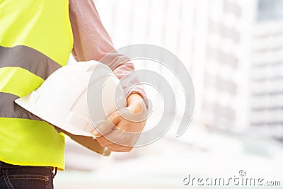 Close up front view of engineering male construction worker holding safety white helmet Stock Photo