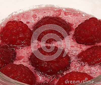 Close-up of a frothy pink smoothie made from raspberries and milk. Delicious diet drink. Milkshake. Stock Photo