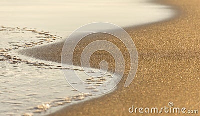 A close up of frothy waves on a stormy day against the golden sandy beach. Copy Paste Stock Photo