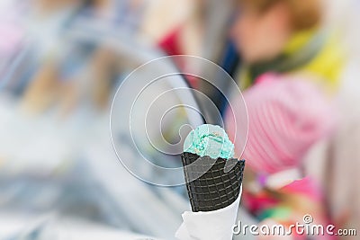 Close-up of fruit Ice-cream green color in Black waffle cone, background with sweet dessert. Real scene in store Stock Photo