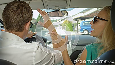CLOSE UP: Furious man and woman argue while they drive through the suburbs. Stock Photo
