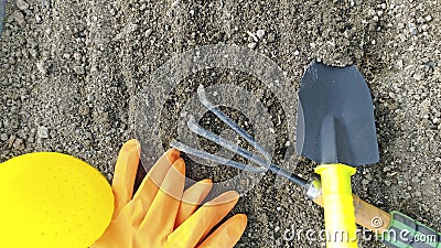 Close-up of garden tools lies on the excavated ground. Preparing the soil for the summer cottage. View from above Stock Photo