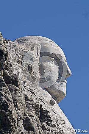 Close up of George Washington`s head on Mount Rushmore with solid blue sky Stock Photo