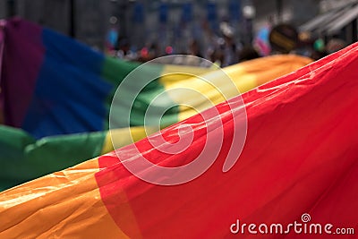 Close up of the giant rainbow LGBT flag at the front of the Gay Pride Parade in London 2018, with people holding the edges. Stock Photo