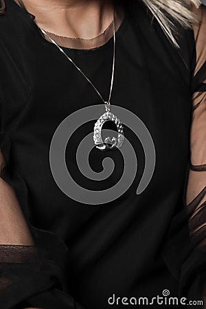 Close-up of girl in black dress and a pendant around the neck, fashion and style of clothing Stock Photo