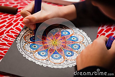 Close-up of girl`s hands coloring a mandala Stock Photo