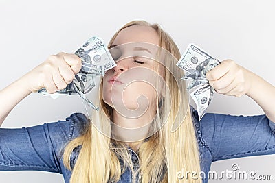 Close-up of a girl sniffing money. Madness and greed from currency. The concept of corruption and getting money at any cost. Stock Photo