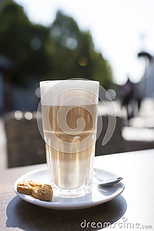 Glass of latte macchiato with spume, spoon and cookie Stock Photo