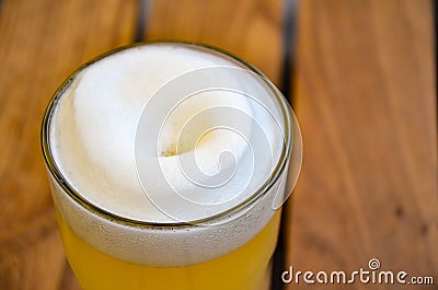 Glass with wheat unfiltered beer and lush white beer foam Stock Photo